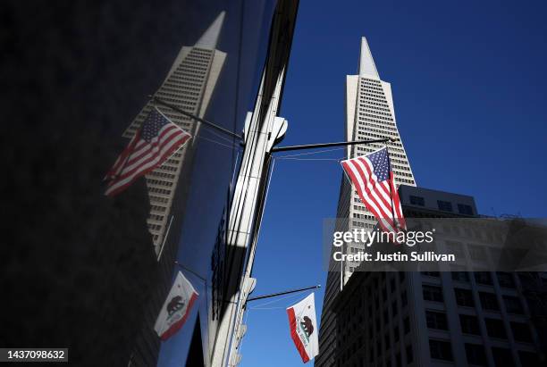 The American flag and the California state flag fly in front of the Transamerica Pyramid building on October 27, 2022 in San Francisco, California....