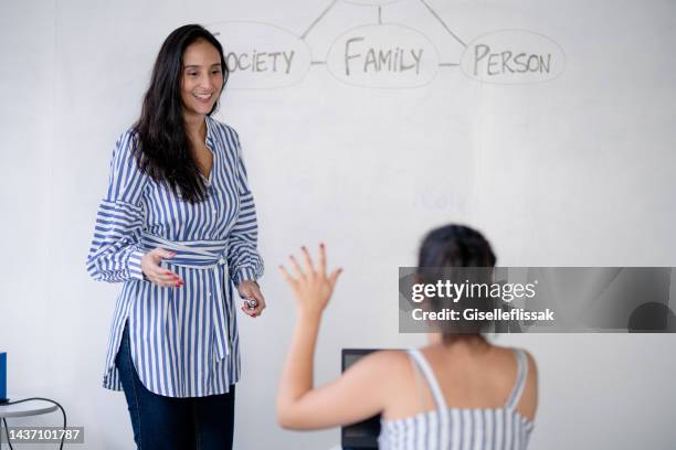 studente delle scuole superiori alza la mano e fa una domanda al docente - english language foto e immagini stock