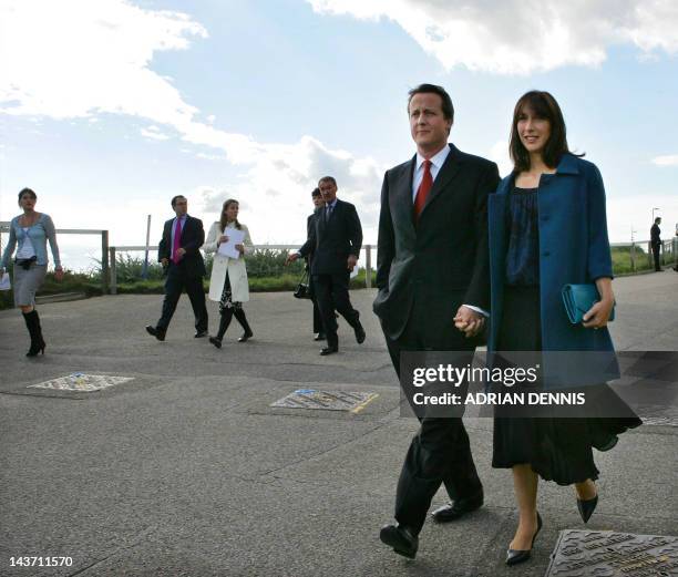 Britain's Conservative Party Leader David Cameron and his wife Samantha make the traditonal walk from their hotel to the conference centre to deliver...