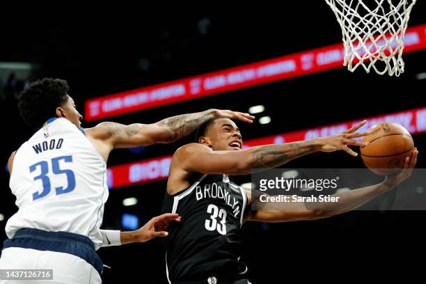 Nic Claxton of the Brooklyn Nets goes to the basket as Christian Wood of the Dallas Mavericks defends during the first half at Barclays Center on...