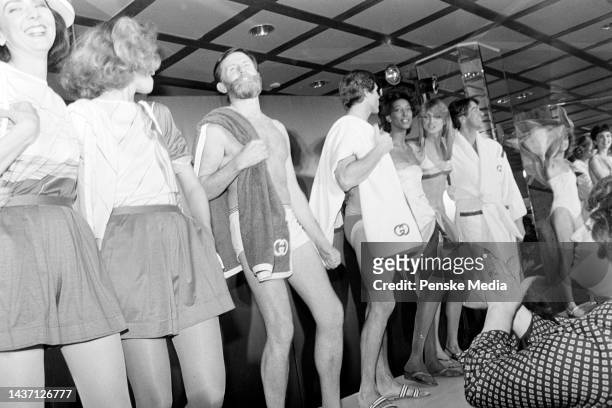 Aldo Gucci poses onstage with models in swimwear from the Gucci summer 1983 menswear collection at the Gucci flagship store in New York.