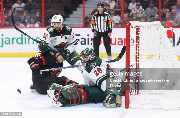 Marc-Andre Fleury of the Minnesota Wild tracks the puck after making a save as his teammate Matt Dumba battles with Derick Brassard of the Ottawa...
