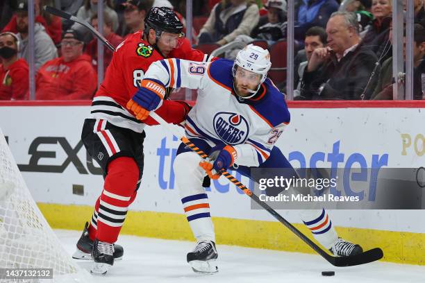 Leon Draisaitl of the Edmonton Oilers and Jack Johnson of the Chicago Blackhawks battle for control of the puck during the first period at United...