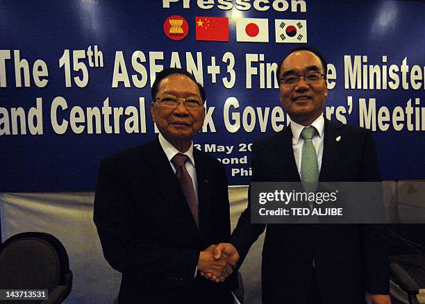 Cambodia's deputy Prime Minister and finance minister Keat Chhon hakes hands with South Korean finance minister Jaewan Bahk after a joint press...