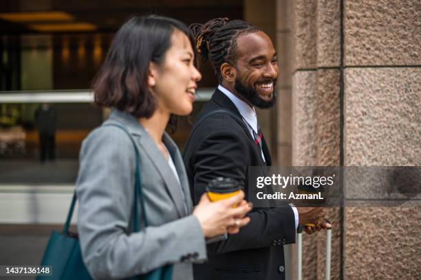 accountants enjoy a cup of coffee on their way to the office - business man woman walking stock pictures, royalty-free photos & images