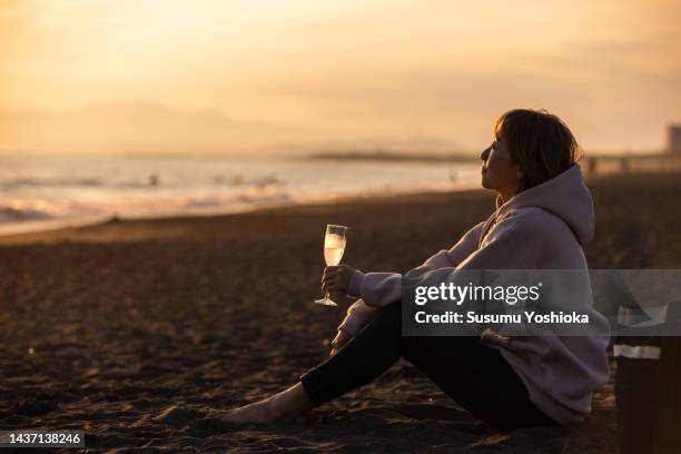 one woman having a good time on the beach in the evening. - relief emotion stock pictures, royalty-free photos & images