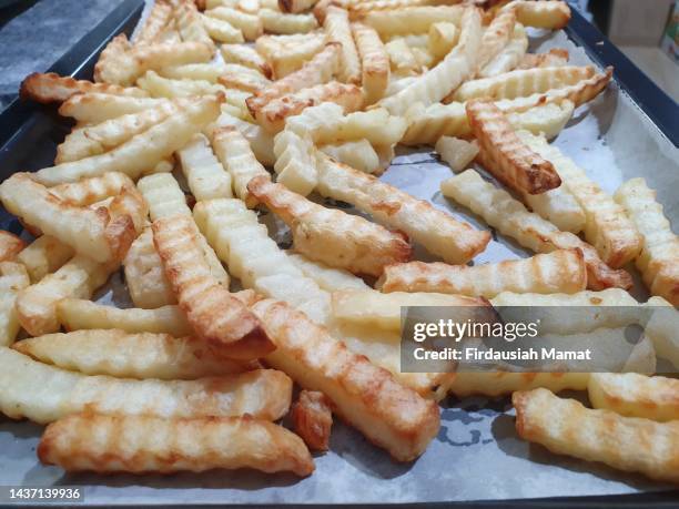 freshly baked potato fries on baking tray - frite four photos et images de collection