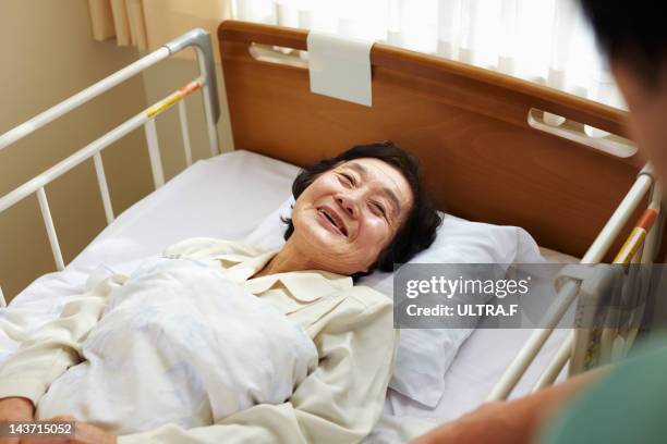 senior woman in hospital bed - nakano ward stock-fotos und bilder