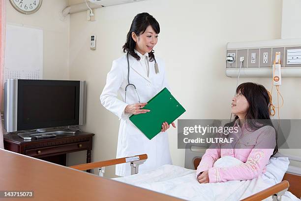 female doctor talking to a patient - nakano ward stock-fotos und bilder