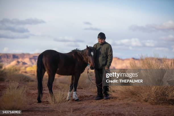 navajo teenager with his horse in monument valley - navajo etniciteit stockfoto's en -beelden