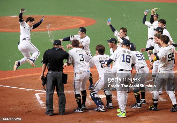 Masataka Yoshida of the Orix Buffaloes is congratulated by his teammates on the home plate as he hits the game-winning two run home run in the 9th...