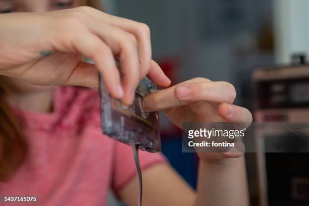 close up of a girl  winding back audio cassette tape with hands - girls boom box stock pictures, royalty-free photos & images