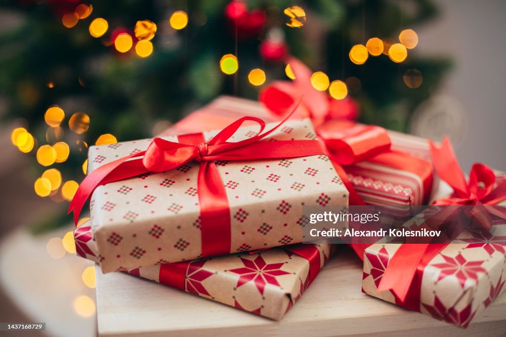 Group of Christmas gifts in front of tree.
