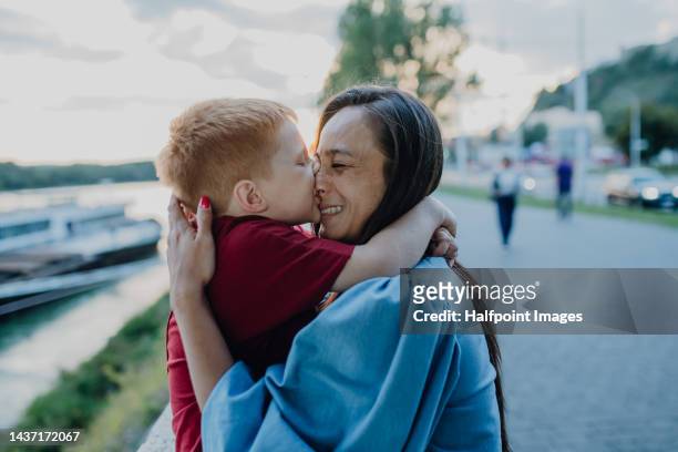 young mother with her little son having fun at boats in the port. - kiss booth stock-fotos und bilder