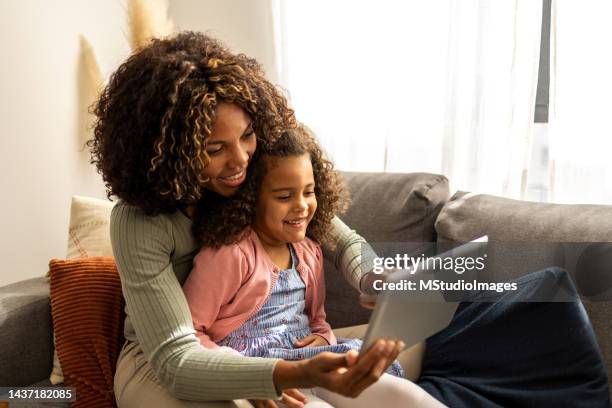 mother and daughter using digital tablet - family tablet bildbanksfoton och bilder