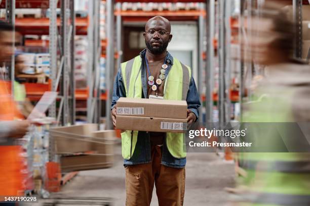 african american warehouseman carrying cardboard boxes - carrying box stock pictures, royalty-free photos & images