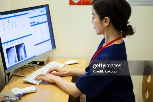 female doctor working in doctor's office - medisch document stockfoto's en -beelden