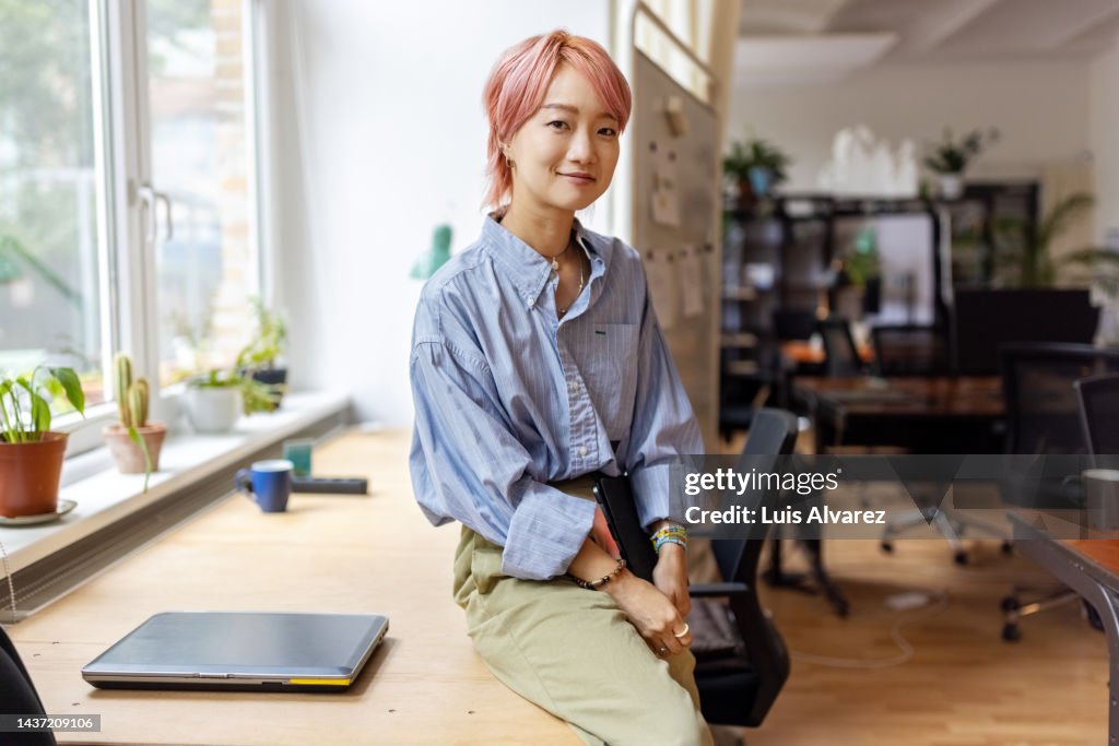 Portrait of confident creative businesswoman smiling in office