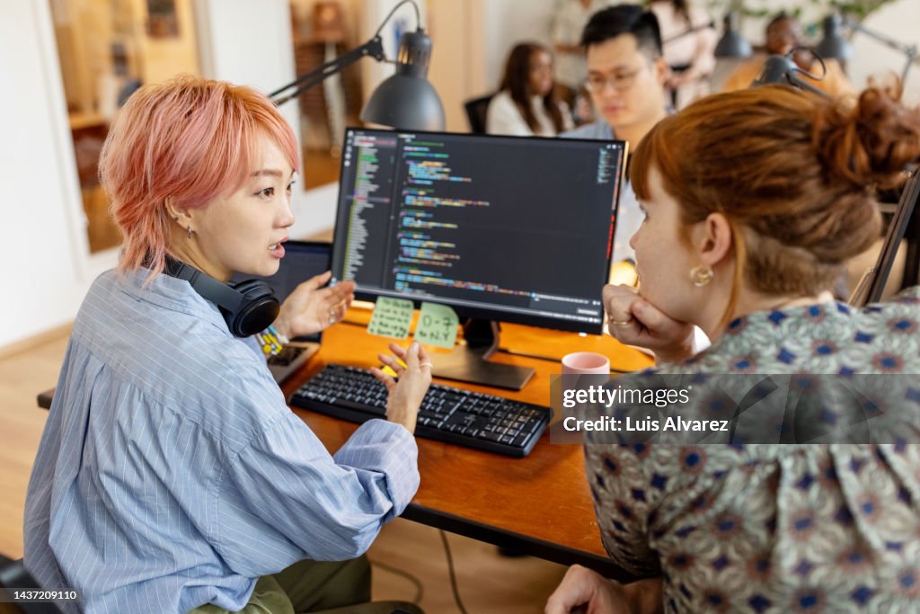 Creative businesswomen discuss over new coding program in the office
