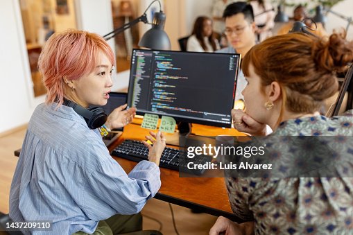 Creative businesswomen discuss over new coding program in the office Creative businesswomen discuss over new coding program in the office