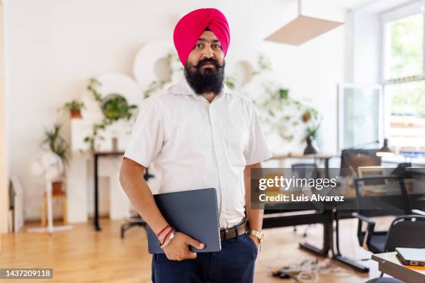 portrait of a turbaned sikh businessman at coworking office space - sikhisme stockfoto's en -beelden