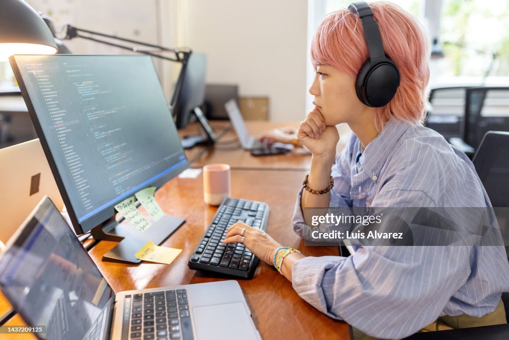 Businesswoman coding on computer at coworking office