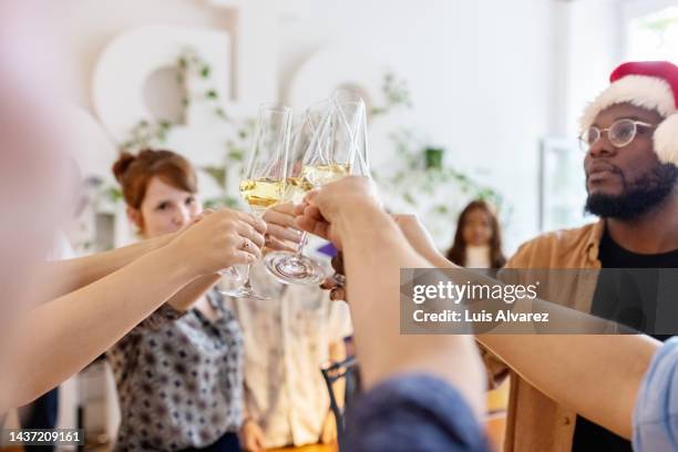 business team toasting champagne during christmas party in office - christmas party office stock-fotos und bilder