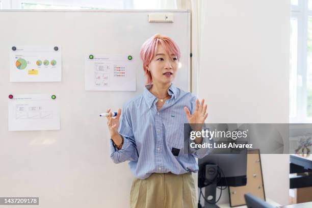 asian businesswoman giving presentation at startup office - geschäftsgründung stock-fotos und bilder