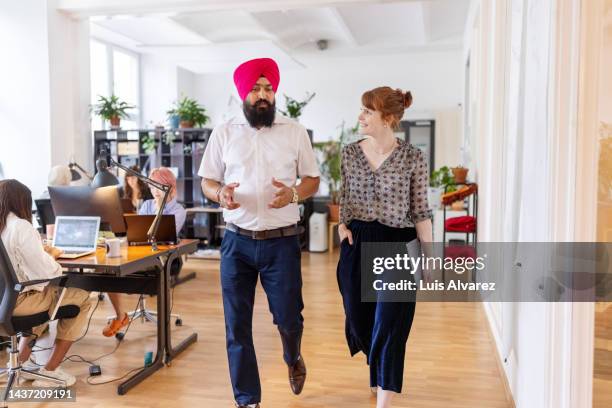 business colleagues moving in the office and discussing work - turban stock pictures, royalty-free photos & images