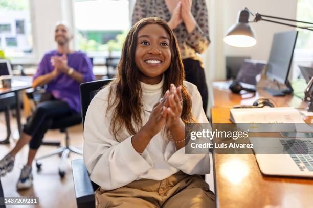 young african woman clapping after presentation at coworking office - congratulating stock pictures, royalty-free photos & images