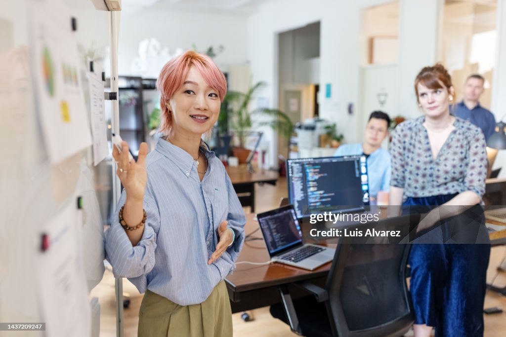Entrepreneur explaining new marketing strategy to colleagues at office