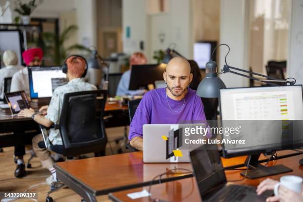 man working on laptop at coworking office - helemaal kaal stockfoto's en -beelden