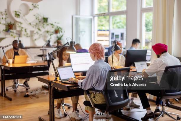 multi-ethnic businesspeople working in the open plan office - small office stock pictures, royalty-free photos & images