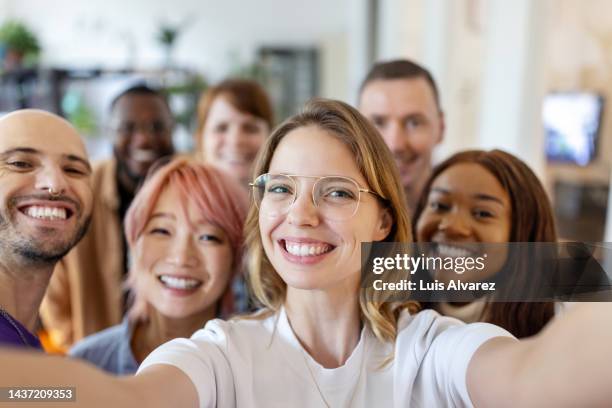 businesswoman taking selfie with team in office - team stock-fotos und bilder