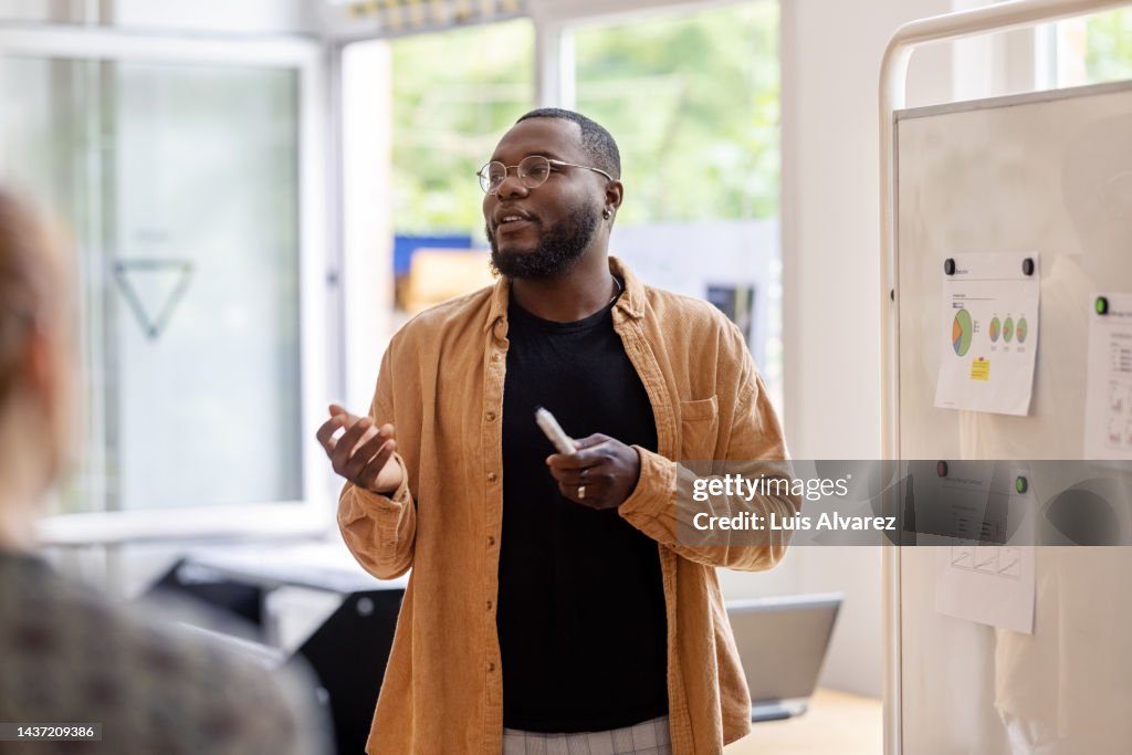 African man giving a presentation to the team at coworking office