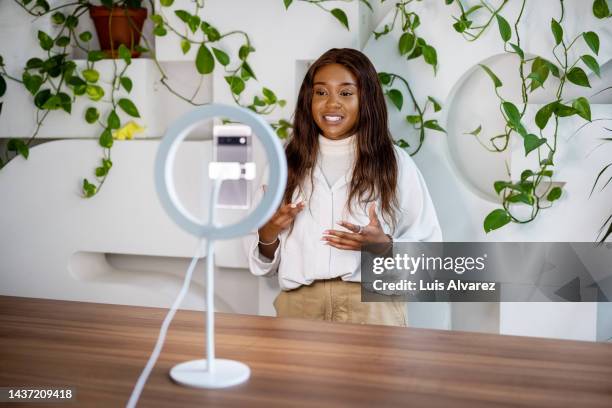 african woman making a video blog with smartphone and ring light at studio. - ladies marketing day stock pictures, royalty-free photos & images