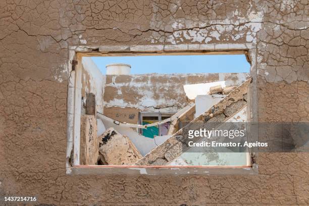 window hole on a withered wall and house interior in ruins - abandoned crack house stock pictures, royalty-free photos & images