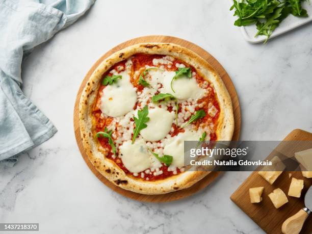 pizza margherita margarita, rustic italian homemade food, topped with pizza sauce from canned tomatoes, mozzarella cheese and arugula, top view - cheese pizza stock-fotos und bilder