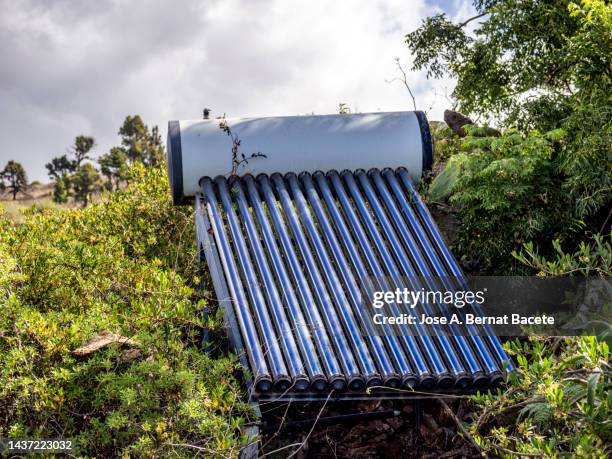 solar panels for the hot water of the house installed in the garden. - electric heater fotografías e imágenes de stock