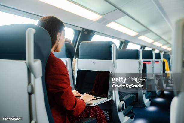 japanese businesswoman traveling by a train and working online - tåginteriör bildbanksfoton och bilder