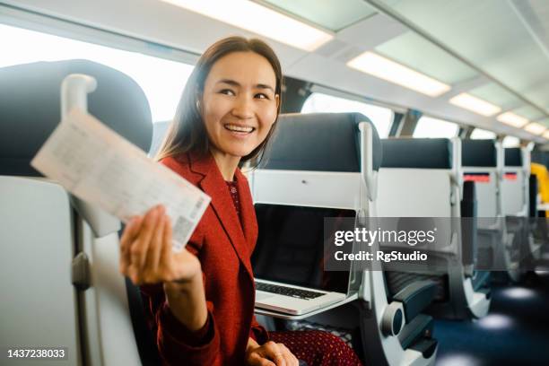 portrait of an asian businesswoman in a train showing the ticket - train ticket stock pictures, royalty-free photos & images