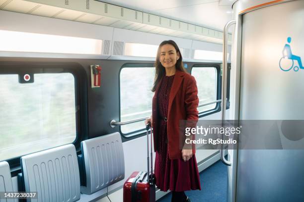 asian woman in a train arriving on her destination - tåginteriör bildbanksfoton och bilder