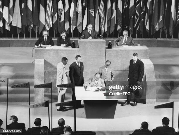 Liberian politician and diplomat Gabriel Lafayette Dennis , surrounded by people, signs the charter at the United Nations Conference on International...