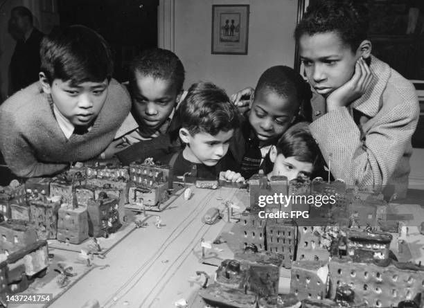 Harlem schoolboys Richard Young, Rufus Young, Guy Webster, Andrew Stokes, Roger Webster, and Adolphus Prince inspect the model they helped build of...