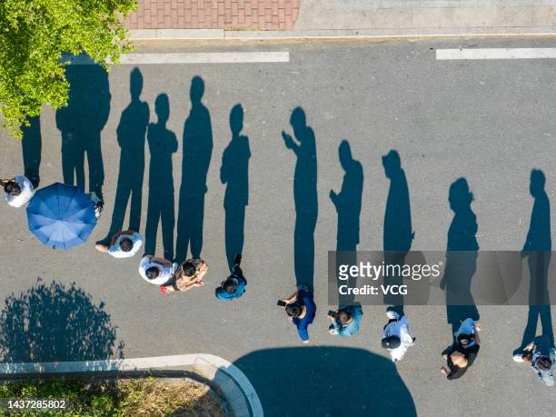 Aerial view of people casting their shadows while lining up for nucleic acid tests on October 28, 2022 in Shantou, Guangdong Province of China.