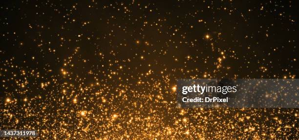 glittering golden particles - sparks fly stock pictures, royalty-free photos & images