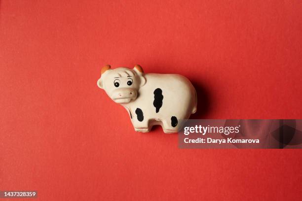 the toy cow from rubber on the isolated red background. baby cute toy for your design. top view, flat lay with copy space. - cute cow stock pictures, royalty-free photos & images