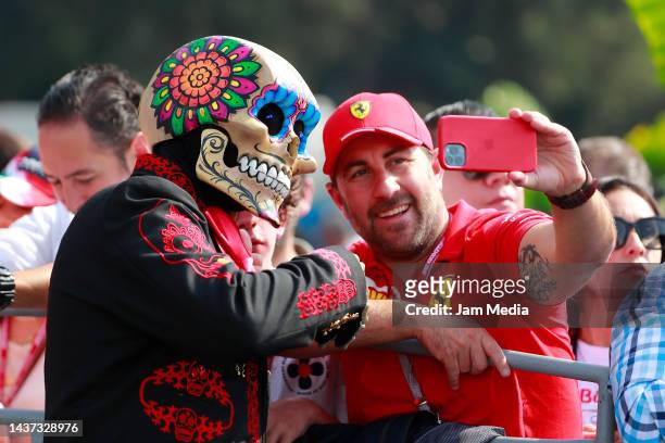 Fans take photos with an entertainer dressed as Calavera in the paddock prior to practice ahead of the F1 Grand Prix of Mexico at Autodromo Hermanos...