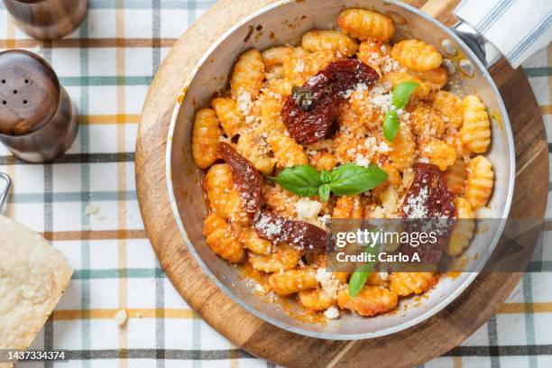 gnocchi in sun-dried tomato sauce - gnocchi stock-fotos und bilder
