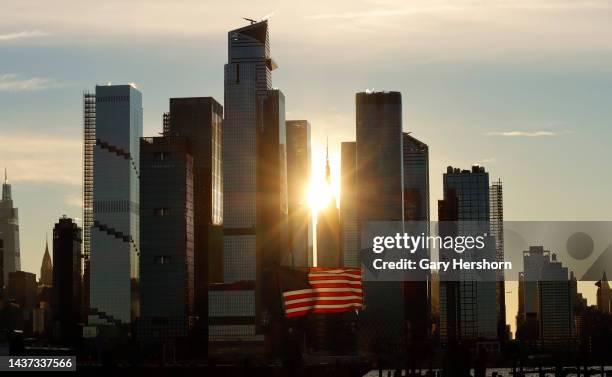 The sun rises behind Hudson Yards and the Empire State Building on October 28 as seen from Weehawken, New Jersey.